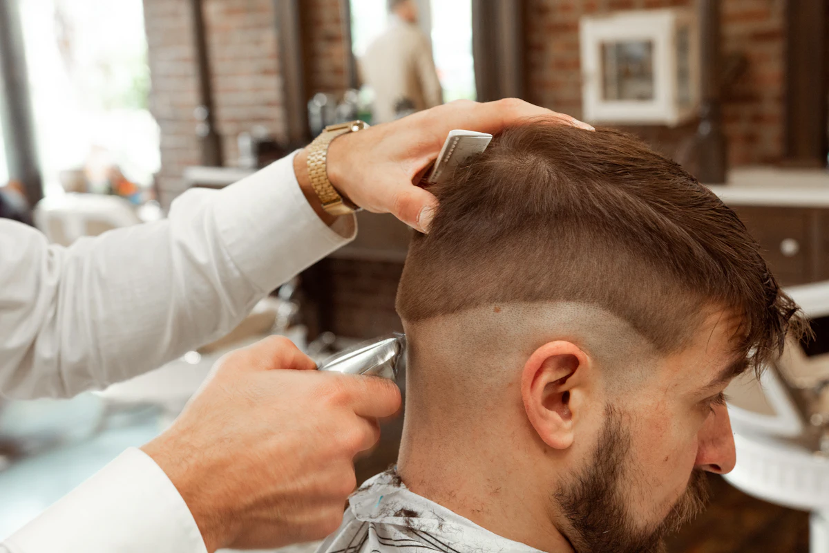 Barbero haciendo un degradado con máquina a un cliente